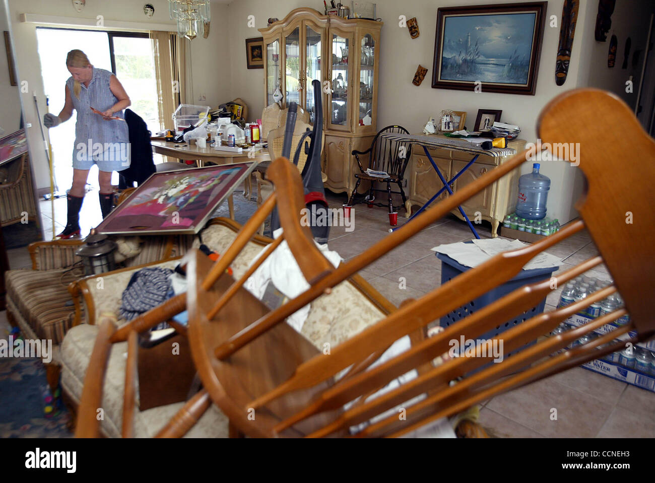 092904 met jeanneStuartHeather Morella, cq, sweeps up broken glass in her home on