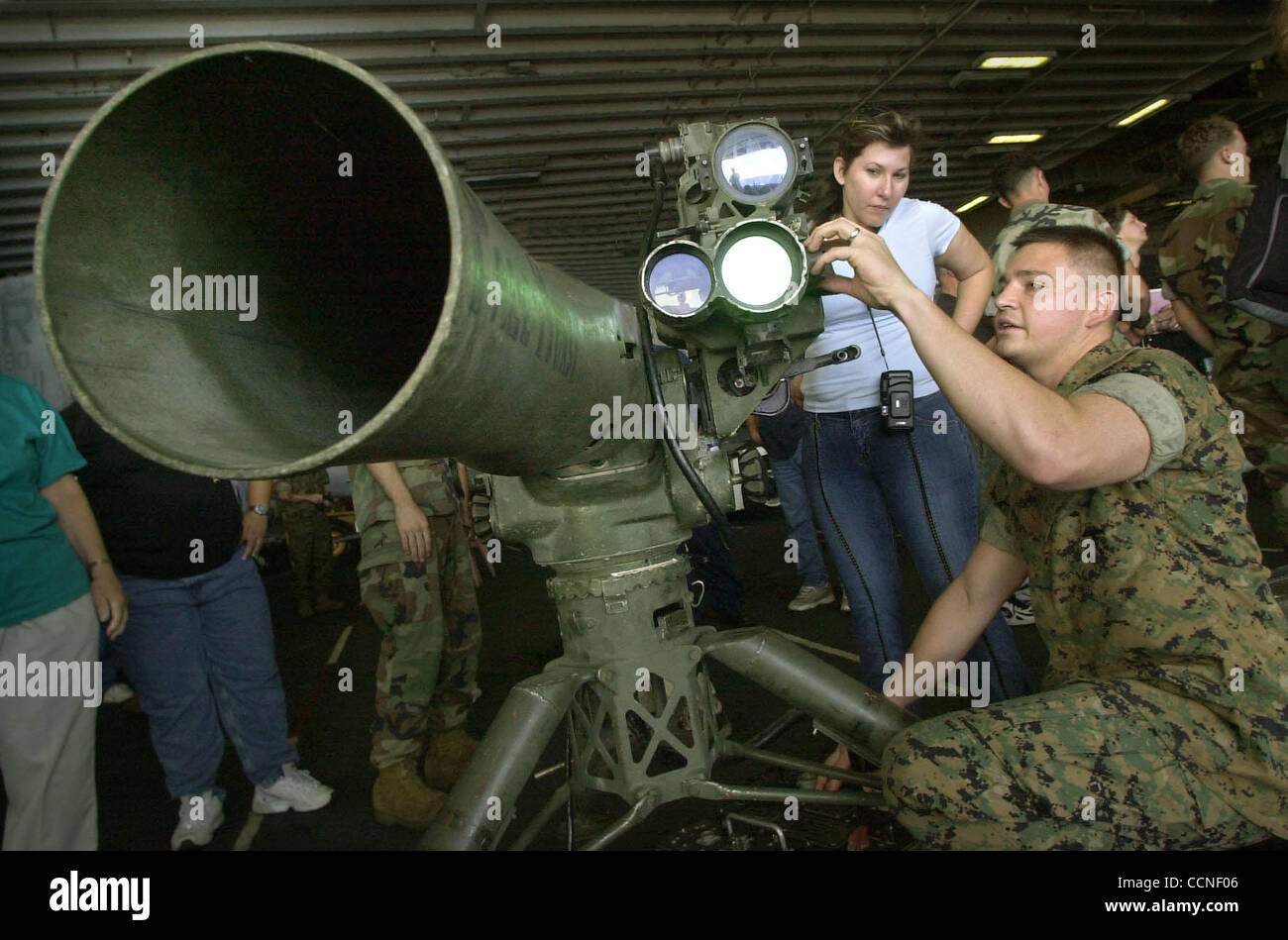 (Published 07/22/2003, A-6): Marine Sgt. Marcelino Barajas, right, demonstrated the TOW (Tube launched, Optically Tracked, Wire-Guided Missile System) missile launcher to Angel Santoyo of San Diego, during a static display of weapons for relatives of crew returning with the USS Tarawa. According to  Stock Photo
