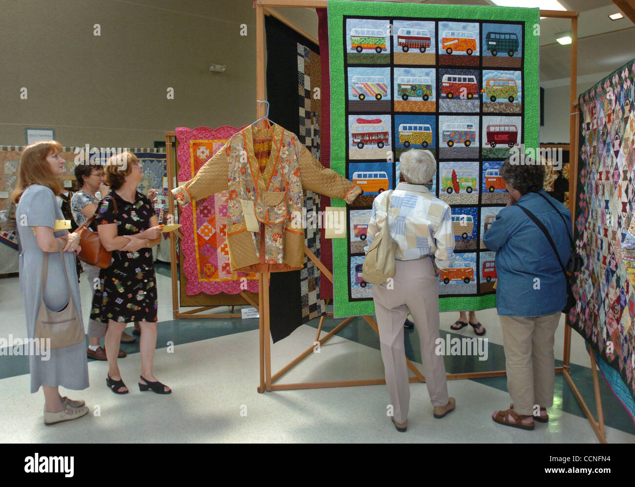 People browse at the annual quilt show at Charlotte Wood Middle School as a quilt titled 'What A Long Wild Trip It Has Been' gets the attention of Jeanne Aitken (cq) of Danville, second from right, and her cousin Sue Arnold of Albany, right, Sunday, September 26, 2004, in Danville, Calif.  (Contra C Stock Photo