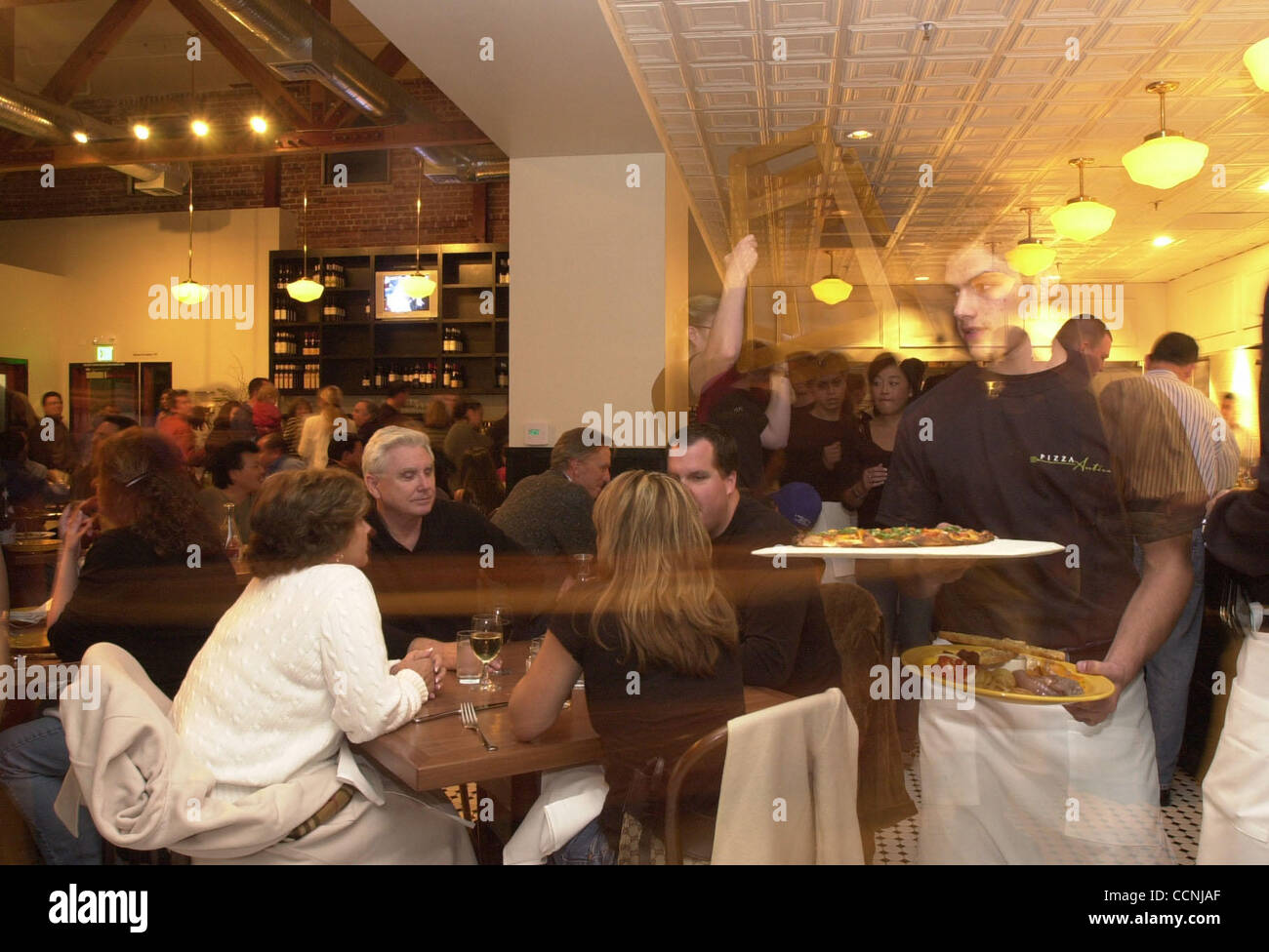 The dining room is packed for a preopening night party at Pizza Antica