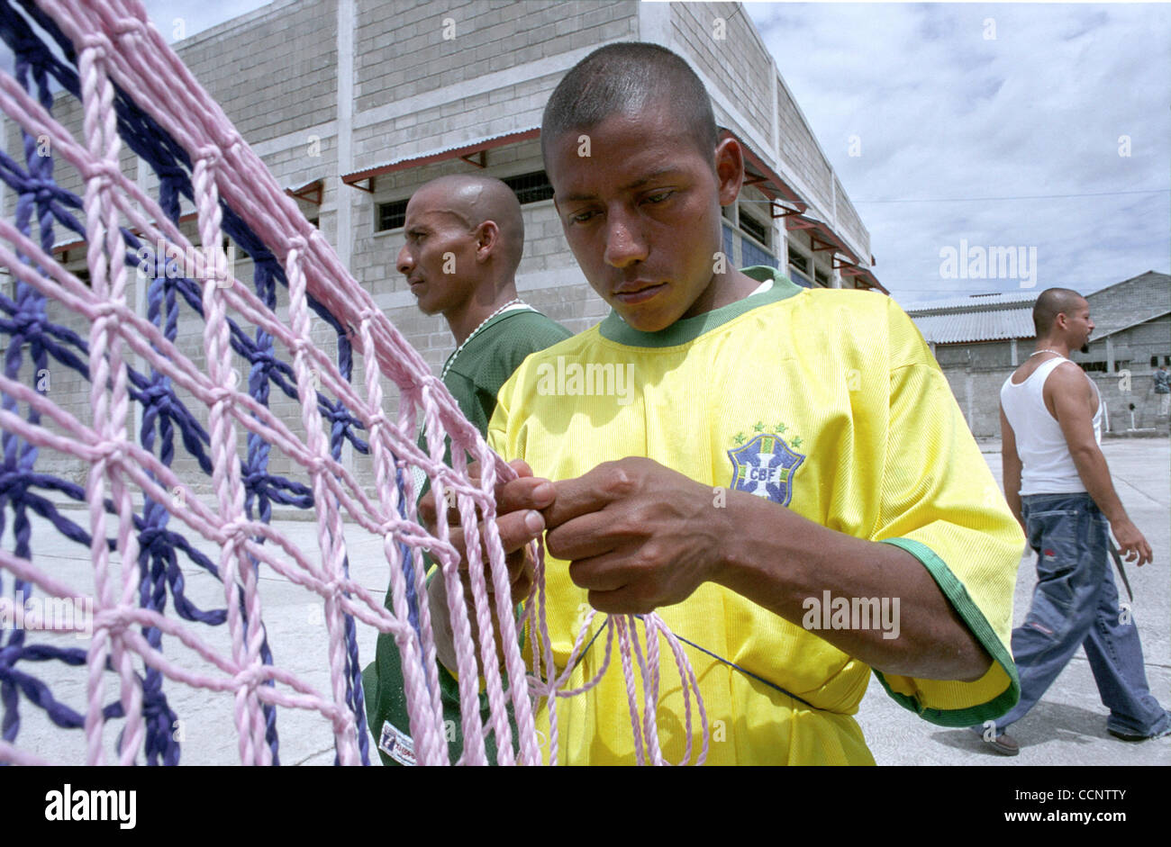 Carlos, 23, weaves yarn into fabric bags in a cellblock at a federal penitenciary near Tegucigalpa, Honduras. Carlos and fellow 18th Street gang members earn money by giving the bags to relatives to sell outside the prison.  Photographer:  Luis J. Jimenez City: Tegucigalpa Country: Honduras Date: Ju Stock Photo