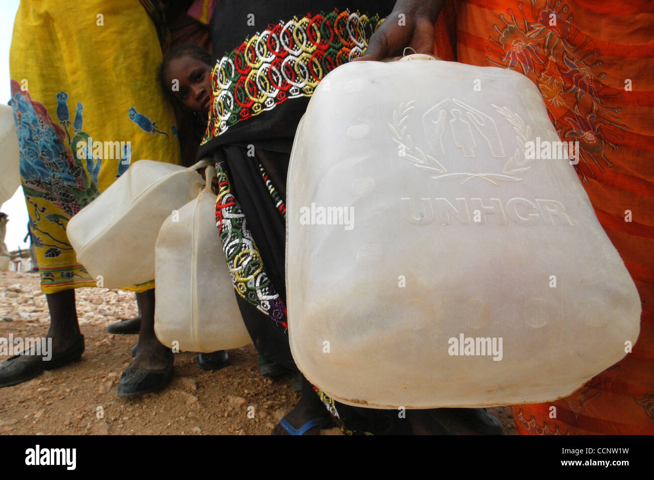 July 16, 2004, Abeche, Chad - Female refugees from neighboring Darfur, Sudan, carry water jugs provided by the United Nations to fetch clean drinking water delivered by an aid agency to a refugee camp in Eastern Chad.  (Credit: David Snyder/ZUMA Press) Stock Photo