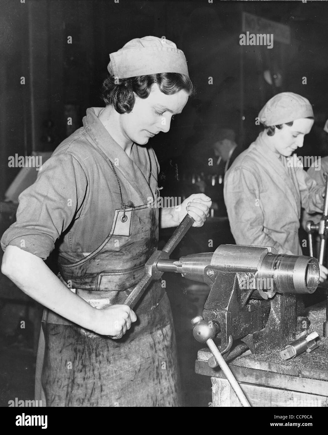 In January 1940 Winston Churchill, then First Lord of the Admiralty and a member of the war cabinet, called for a million women to help with war work, chiefly in the making of munitions. This picture was used to try to help promote that call Ð a woman works on making a shell casing at a factory in S Stock Photo