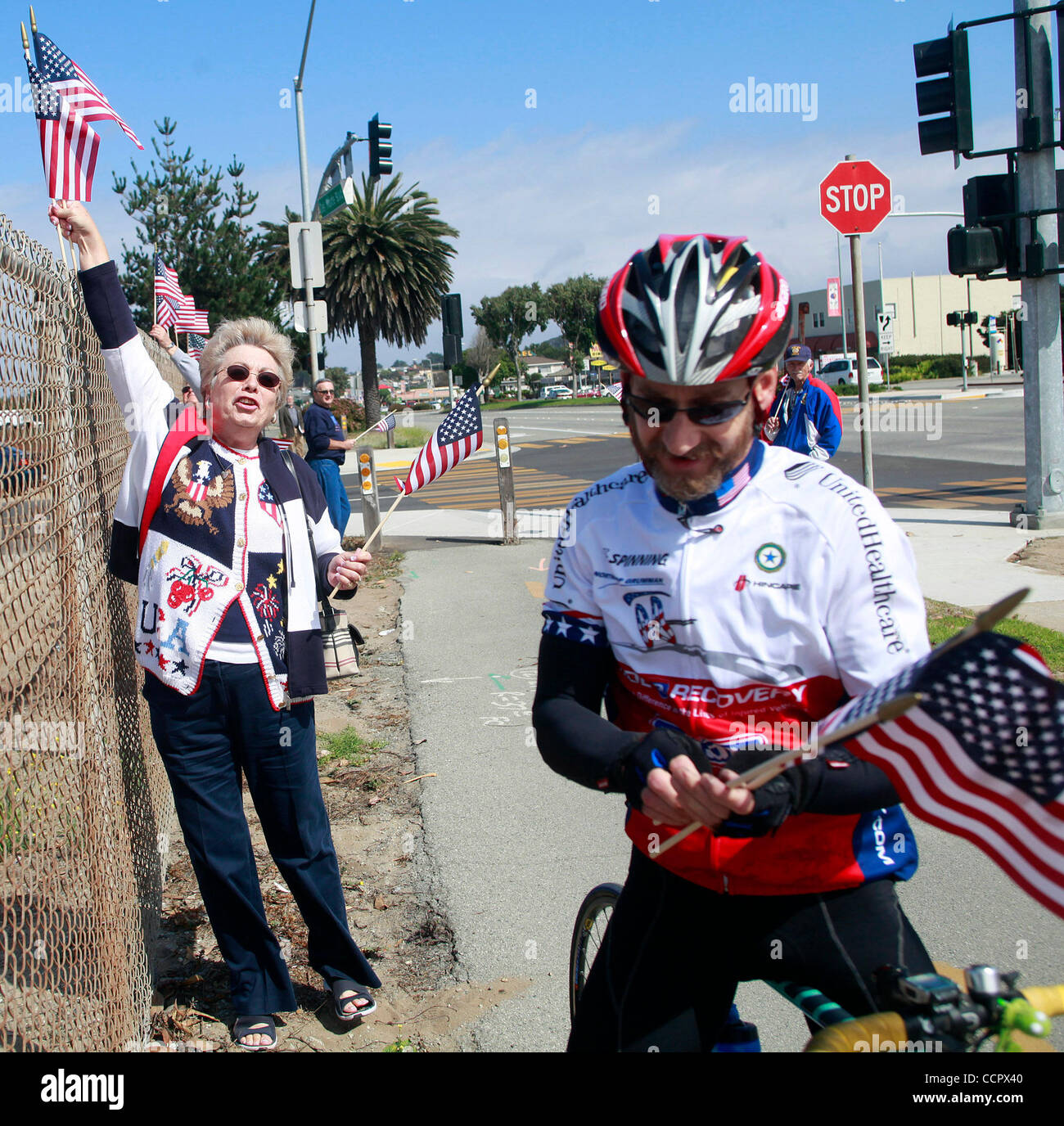 Oct. 4, 2010 - Marina, California, U.S. - RUBY KAPSALIS grabs American flags for ROGER COGGINS and other riders as the American Legion and Auxiliary Monterey Cyprus Unit Post 694 welcome riders as they pass through Marina, Calif. as wounded veterans took part in Ride 2 Recovery's cycle from San Fran Stock Photo