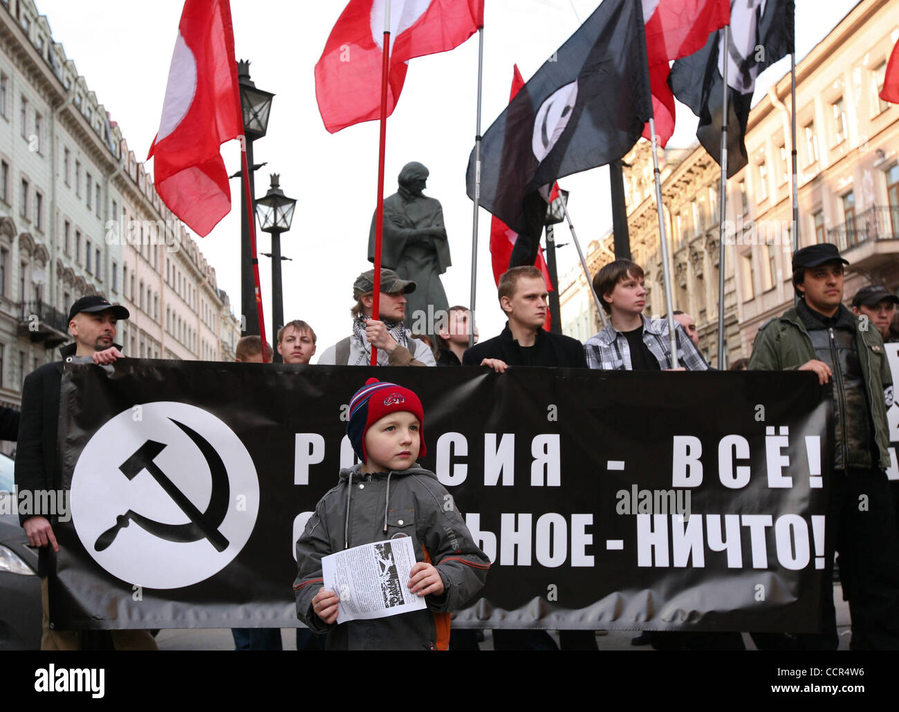 Russian nationalists of the forbidden National Bolshevik party (NBP)with their flags and symbolics at a protest rally in St.Petersburg. Russian radical nationalists protested against NATO . The rally was held under nationalistic slogan (on the placard) of : `Russia Above All, All the Rest is Nothing Stock Photo