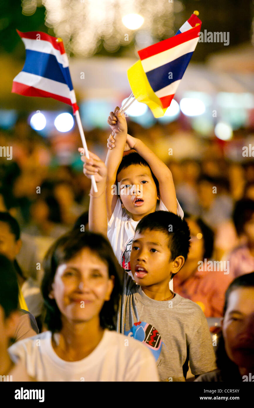 Children wave Thai flags during coronation day celebration in Bangkok. May 5th is Thailand public holiday and the Coronation Day of the worldÕs longest reigning monarch. Thai King Bhumibol Adulyadej came to the throne in June 1946 after the death of his brother, King Ananda. Stock Photo