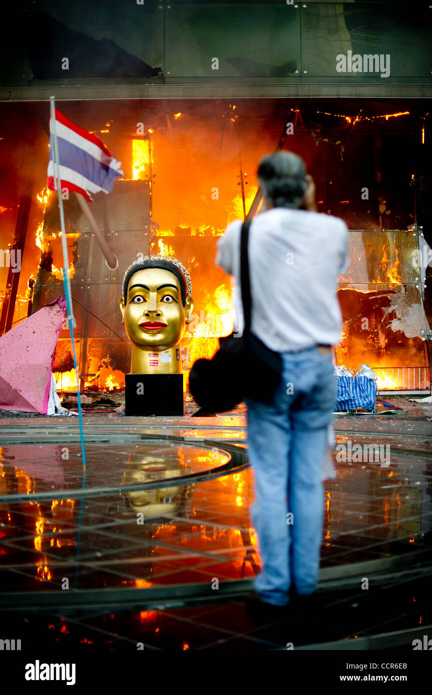 JAMES NACHTWEY, A famous photojournalist takes photos of burning Central World Plaza after it was set alight by Red Shirts protesters. Red Shirts leaders have now surrendered and told thousands of Red Shirts protesters to end their months-long protest after Thai army assault on their fortified camp. Stock Photo