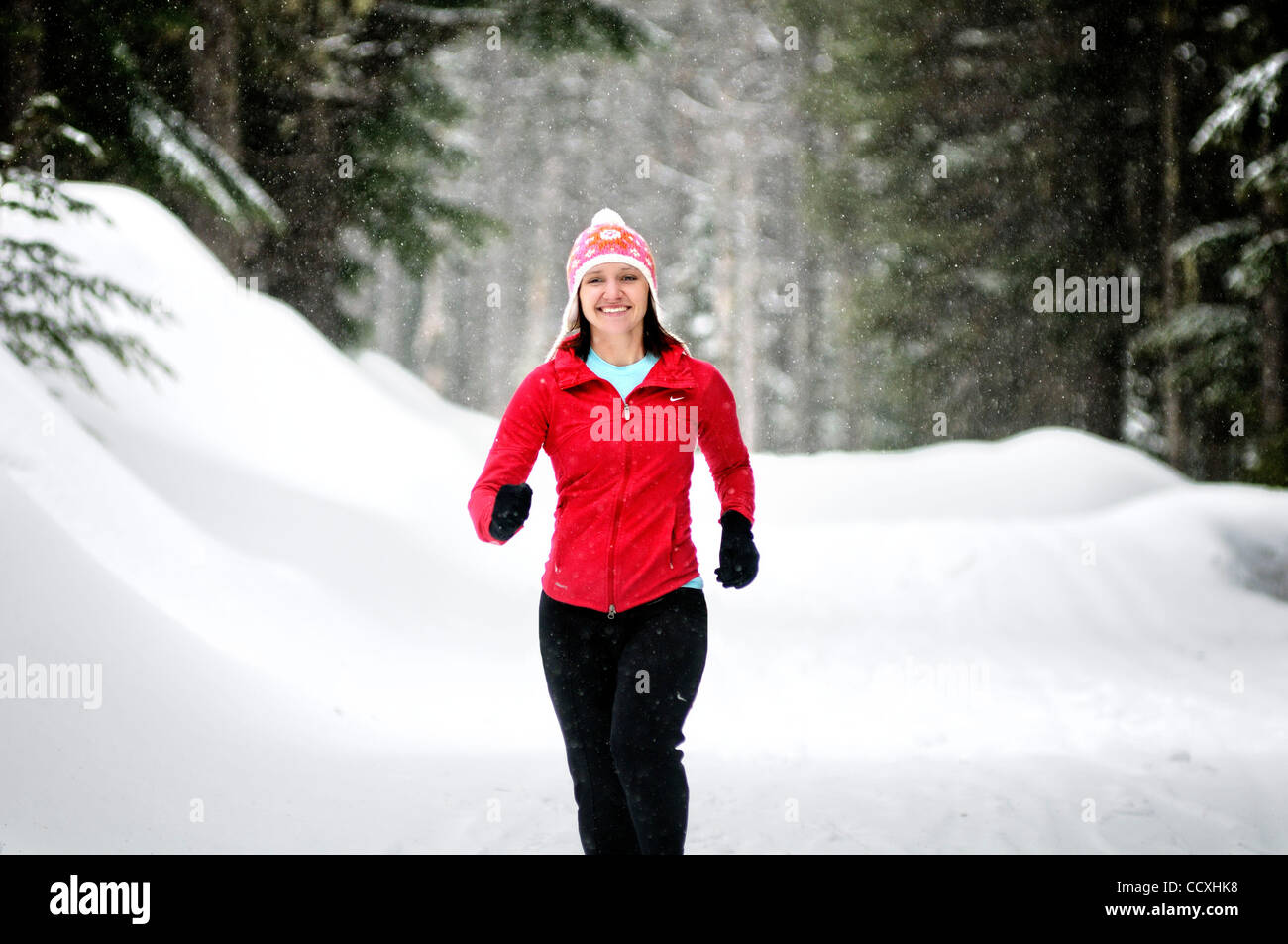 Apr. 01, 2010 - Spokane, Washington, USA - Linda Lilard is an elite runner with the running club Team Swift based out of Spokane, Washington. She runs at Mt. Spokane Ski Resort on a snowy spring day dressed in winter running gear and running through evergreen trees, snow, trails on a cloudy winter l Stock Photo