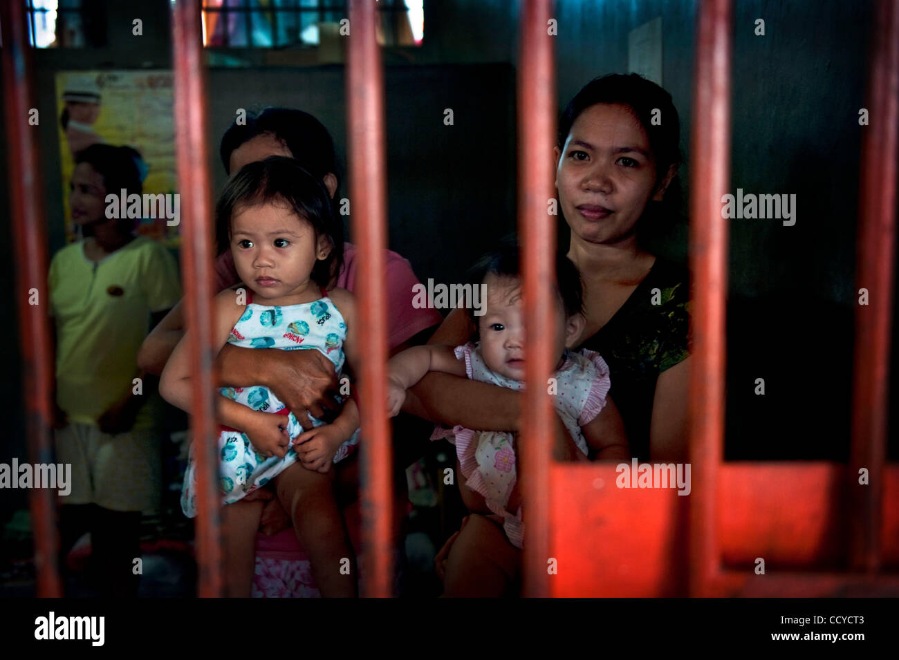 May 07, 2010 - Cotabato City, Mindanao, Philippines - 07 May 2010 Cotabato city, Mindanao Philippines..Female inmates hold ther children inside the cell during the daily family visit. Children spend whole day in prison with their mothers. Prison houses 130 inmates out of which 8 women while the buil Stock Photo
