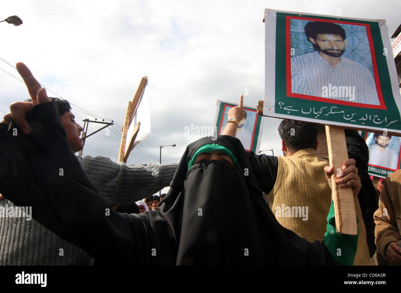 A Kashmiri Muslim woman shouts slogans near pictures of a "missing ...
