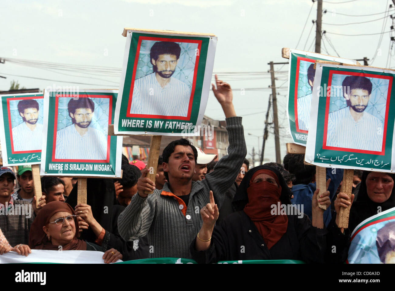 A Kashmiri Muslim woman shouts slogans near pictures of a "missing ...