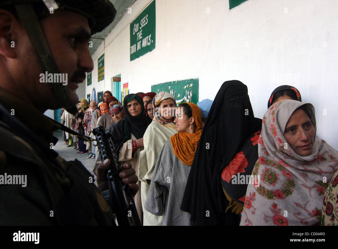 Kashmiri Muslim women wait in line at a polling station to cast their ...