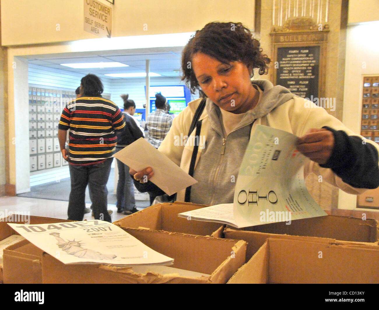 Apr 15, 2008 - Cincinnati, Ohio, USA - Some taxpayers waited to the very last minute to do their taxes. This woman had barely over an hour to complete her tax return as she was reading it inside the post office at the main postal facility in downtown Cincinnati. Unlike previous years, this was the o Stock Photo