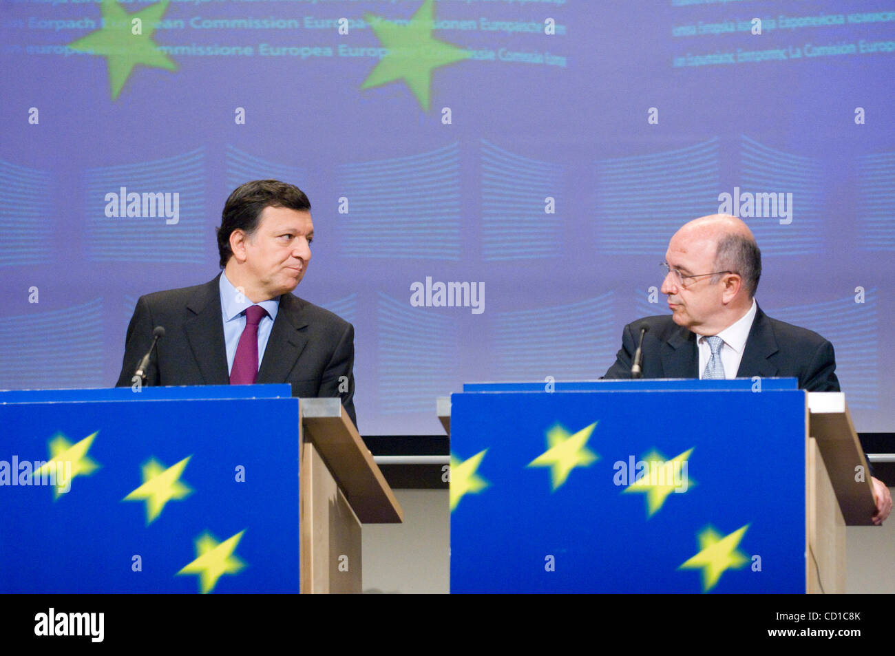 EU Commission President Jose Manuel Barroso, left, looks at EU Commissioner for Economy and Monetary Affairs Joaquin Almunia, as he addresses the media at the European Commission headquarters in Brussels, Wednesday, Oct. 29, 2008. The European Commission says it wants to more than double its crisis  Stock Photo