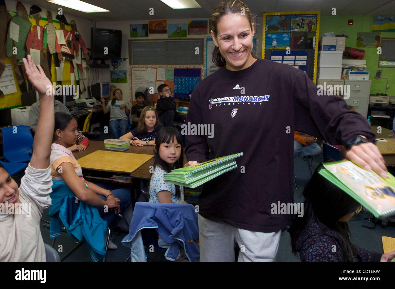WNBA player Ticha Penicheiro from the Sacramento Monarchs hands out