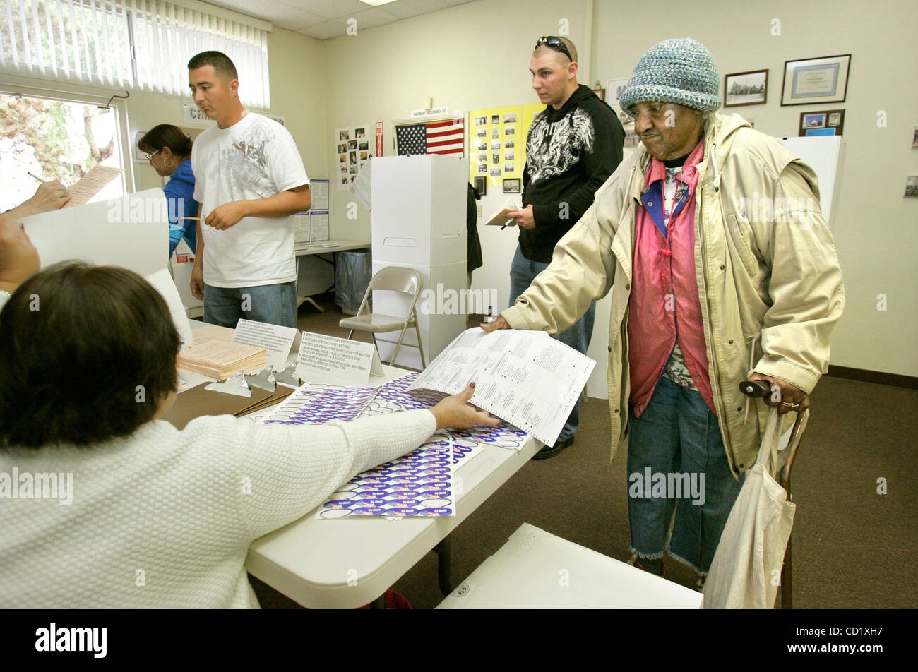 November 4 2008, Oceanside, CA, USA IDA LOWE, 79, hands her ballot to polling place worker PRECY JOVELLANOS (cq) after voting at the Chavez Resource Center in Oceanside's Joe Balderrama Park Credit: photo by Charlie Neuman, San Diego Union-Tribune/Zuma Press. copyright 2008 San Diego Union-Tribune Stock Photo