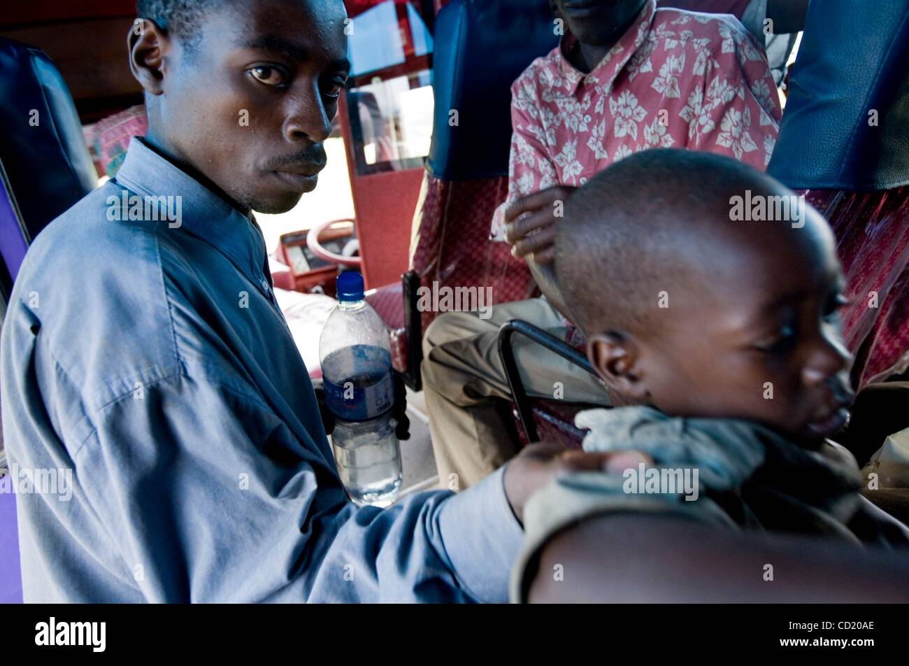 Nov 08, 2008 - Ishasha, Uganda - A father helps his son climb in to a charter bus that will move Congolese refugees to a UNHCR refugee camp in Nakivale. UNHCR moved 258 refugees to the Nakivale camp, about 300 kilometers (186 miles) from the Congo border, adding to the roughly 1,500 refugees who hav Stock Photo
