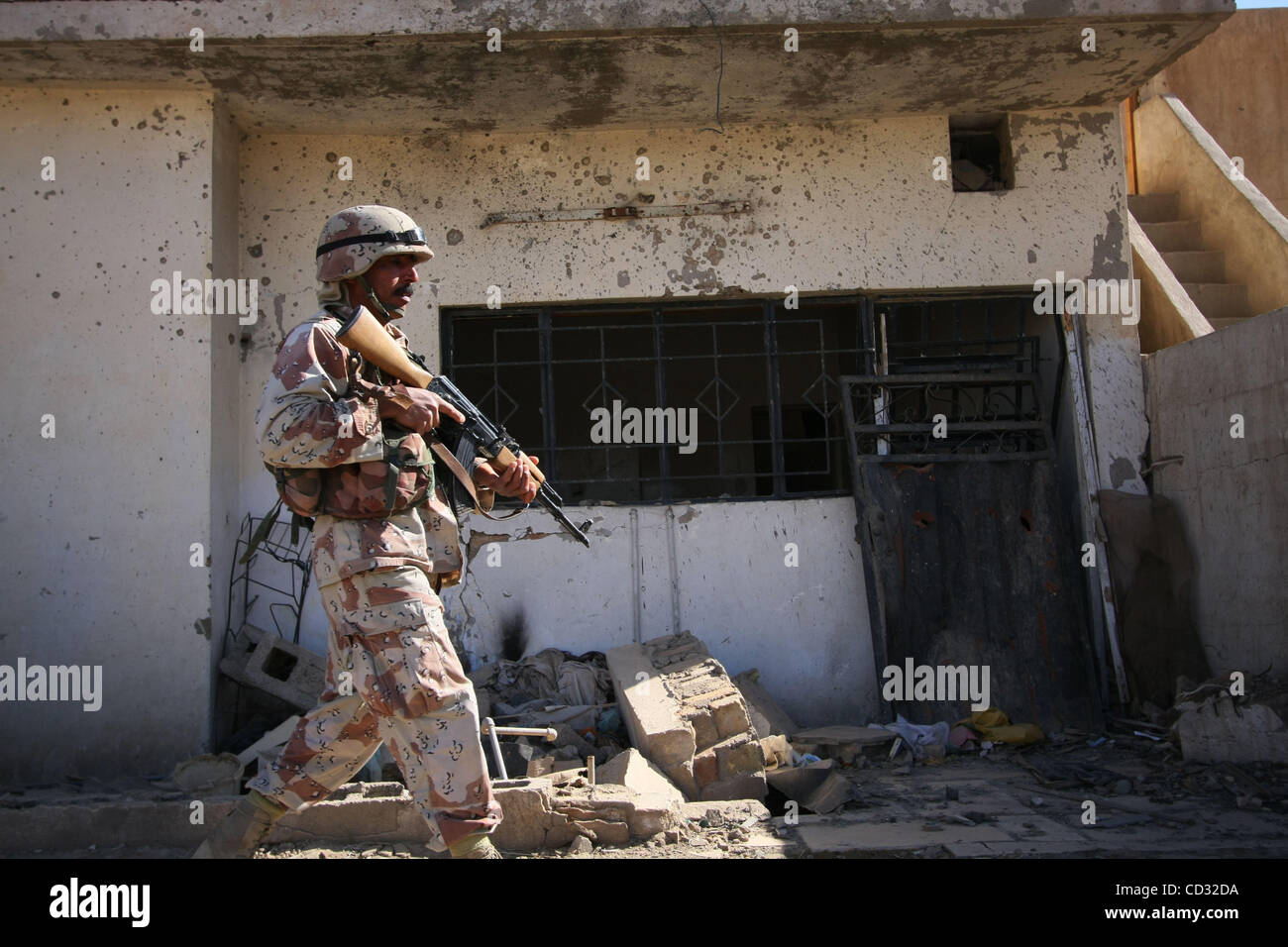Apr 03, 2008 - Baghdad, Baghdad, Iraq - A soldier of the Iraqi Army passes a burnt out building while on a joint patrol with US Forces in the al Dora district of Baghdad. (Credit Image: © Simon Klingert/ZUMA Press) Stock Photo