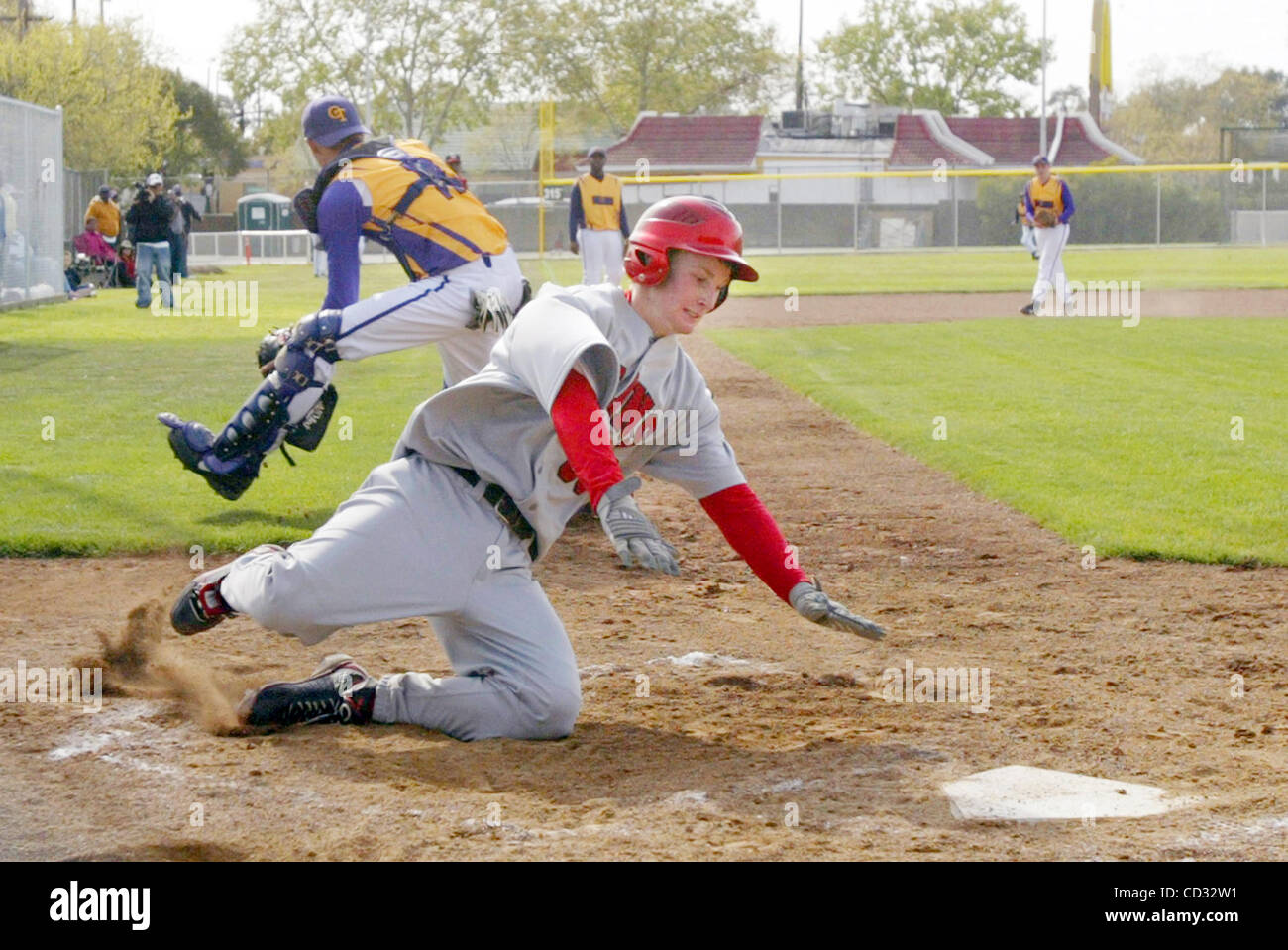 Skyline's Rickey Fitzsimmons dives safe at home plate as Oakland Tech's cathcer Ryan Brekke awaits for the throw during the second inning of their OAL  game at Carter Field in Oakland, Calif., on Friday Apr. 4, 2008. (Ray Chavez/The Oakland Tribune) Stock Photo