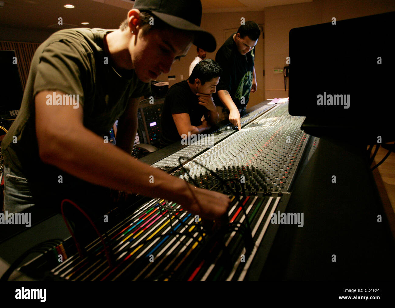 October 6, 2008,  San Diego,  California, USA    DANIEL CABEZA DE BACA (cq), left, plugs in microphone connections while MARCO RODRIGUEZ, seated, and SCOTT JORDAN work their way through the levels on the soundboard.  A high end state-of-the-art music recording studio was constructed at Southwestern  Stock Photo