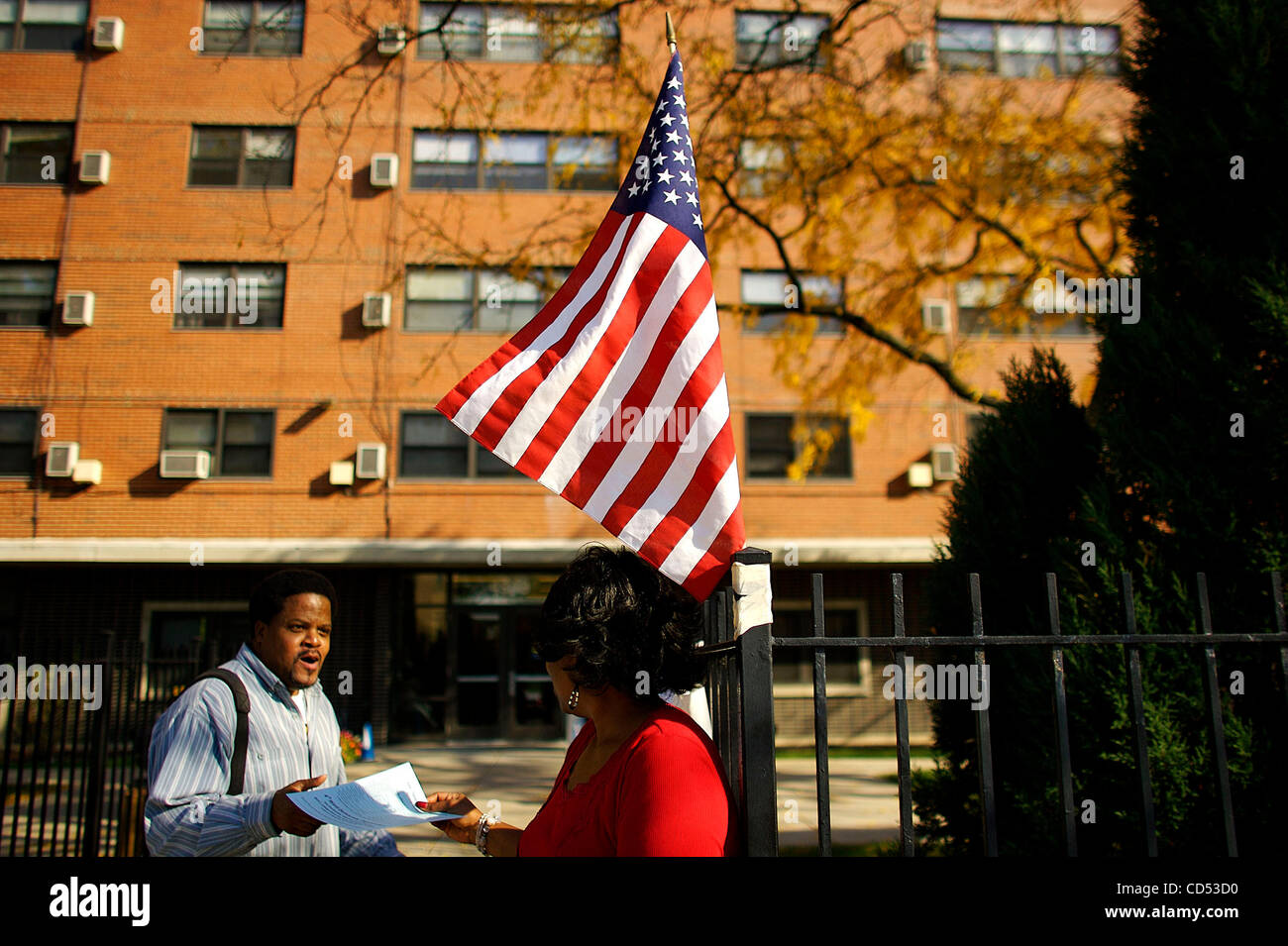 a Poll worker and Obama volunteer hands out sample ballots to voters at a polling station on the South side of Chicago. Stock Photo