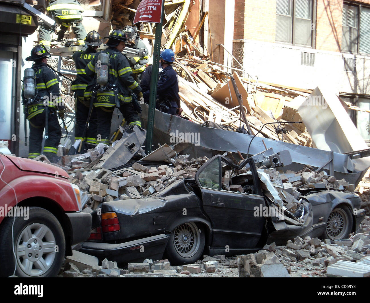 firefighters work amid the rubble of a building after a crane collapsed ...