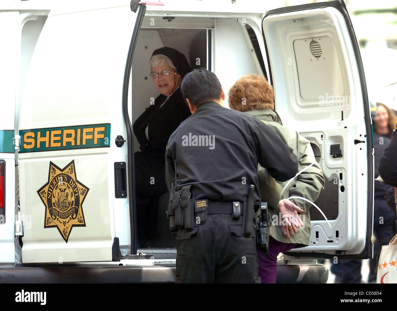 A woman in nun's clothes waits in a paddy wagon after being arrested along with other demonstrators who blocked the intersection of Market and Montgomery Streets in San Francisco's financial district  protesting the fifth anniversary of the Iraq War. More than a hundred arrests were made at the lunc Stock Photo