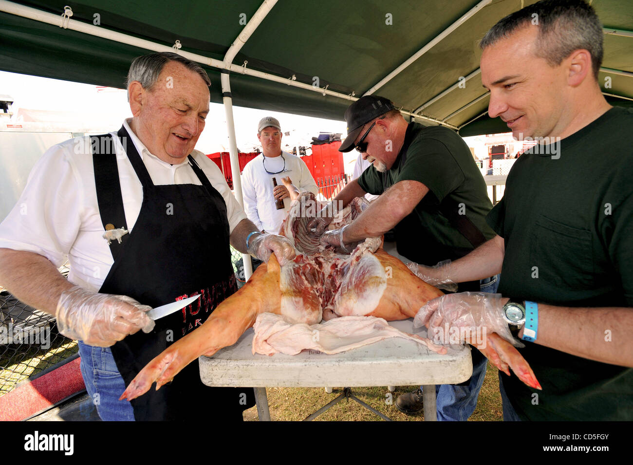 May 15, 2008 - Memphis, Tennessee, USA - Prepping their pig for its 24 hours of low and slow cooking are, from left, pit master PAT BURKE, TOM WELTON, and CLAY COCHRAN, members of Tower Rock, one of the 40 teams competing in the whole hog category at the 31st annual Memphis in May World Championship Stock Photo