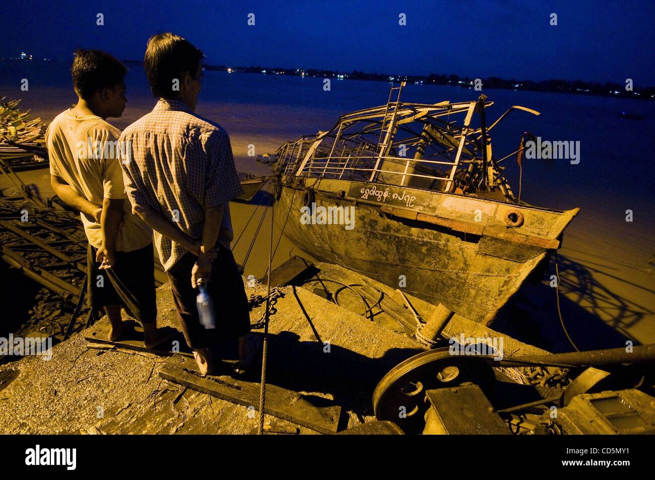 Aug. 26, 2008 - Rangoon, Burma - Two Burmese fishermen peer out over the carcass of a trawler sunken in shallow water by Cyclone Nargis. Even three months later reminders of the disaster can be found everywhere.  (Credit Image: © Austin Andrews/zReportage.com/ZUMA) Stock Photo