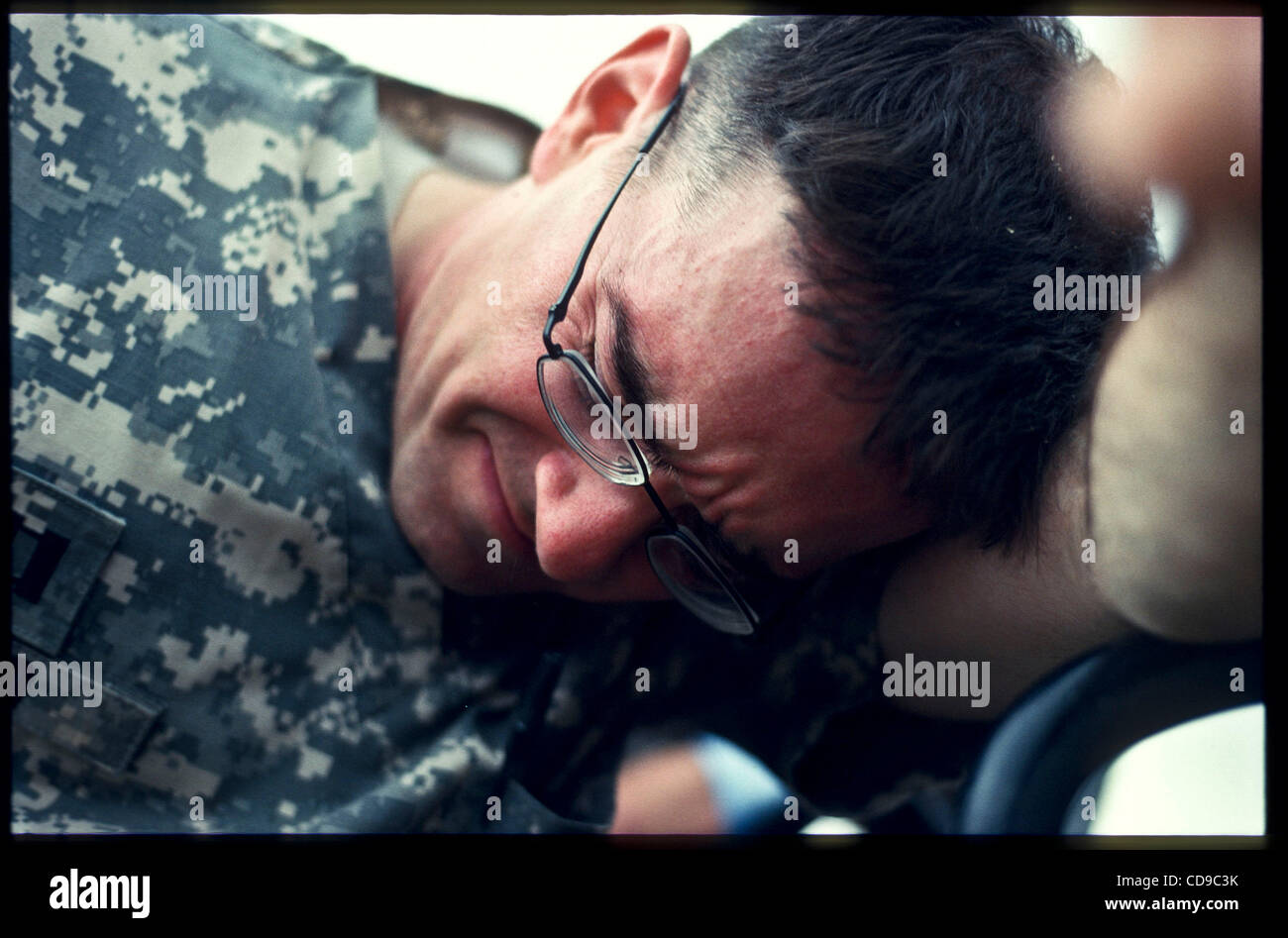 Jul 01, 2010 - Paktika, Afghanistan - Capt. DREW BAIRD, a doctor with Abu Company, 1st Battalion, 187th Infantry Regiment, shields his eyes from dust kicked up by a UH-60 Black Hawk helicopter landing at Forward Operating Base Boris to pick up an Afghan National Army soldier wounded by an insurgent  Stock Photo