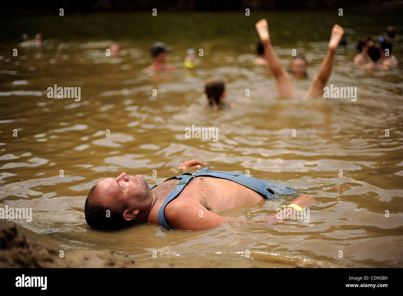 SATURDAY JULY 10, 2010 EAST DUBLIN, GEORGIA -A drunk Redneck Games participant  lies in the river at Buckeye Park during the Redneck Games in East Dublin, Georgia. The games started in 1996 as spoof on the Olympics which were being held in Atlanta, Georgia at the time. participants compete in events Stock Photo
