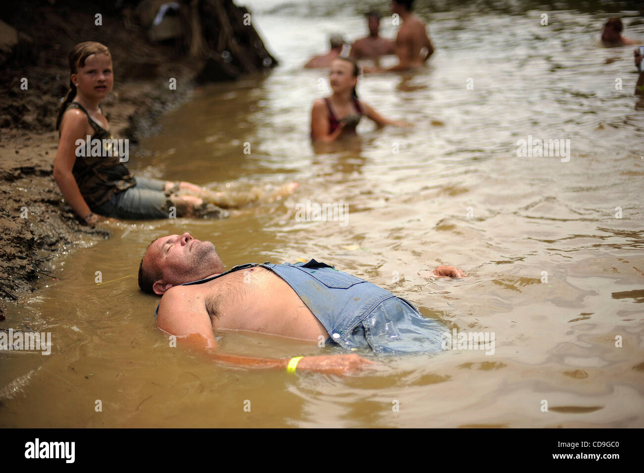 SATURDAY JULY 10, 2010 EAST DUBLIN, GEORGIA -A drunk Redneck Games participant  lies in the river at Buckeye Park during the Redneck Games in East Dublin, Georgia. The games started in 1996 as spoof on the Olympics which were being held in Atlanta, Georgia at the time. participants compete in events Stock Photo