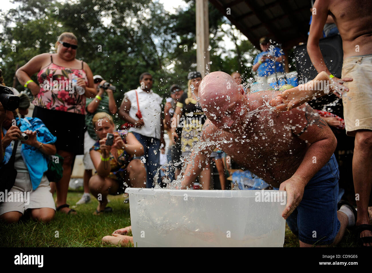 SATURDAY JULY 10, 2010 EAST DUBLIN, GEORGIA - A Redneck Games throws a pig's foot with his mouth during the bobbing for pigs feet contest at Buckeye Park during the Redneck Games in East Dublin, Georgia. The games started in 1996 as spoof on the Olympics which were being held in Atlanta, Georgia at  Stock Photo