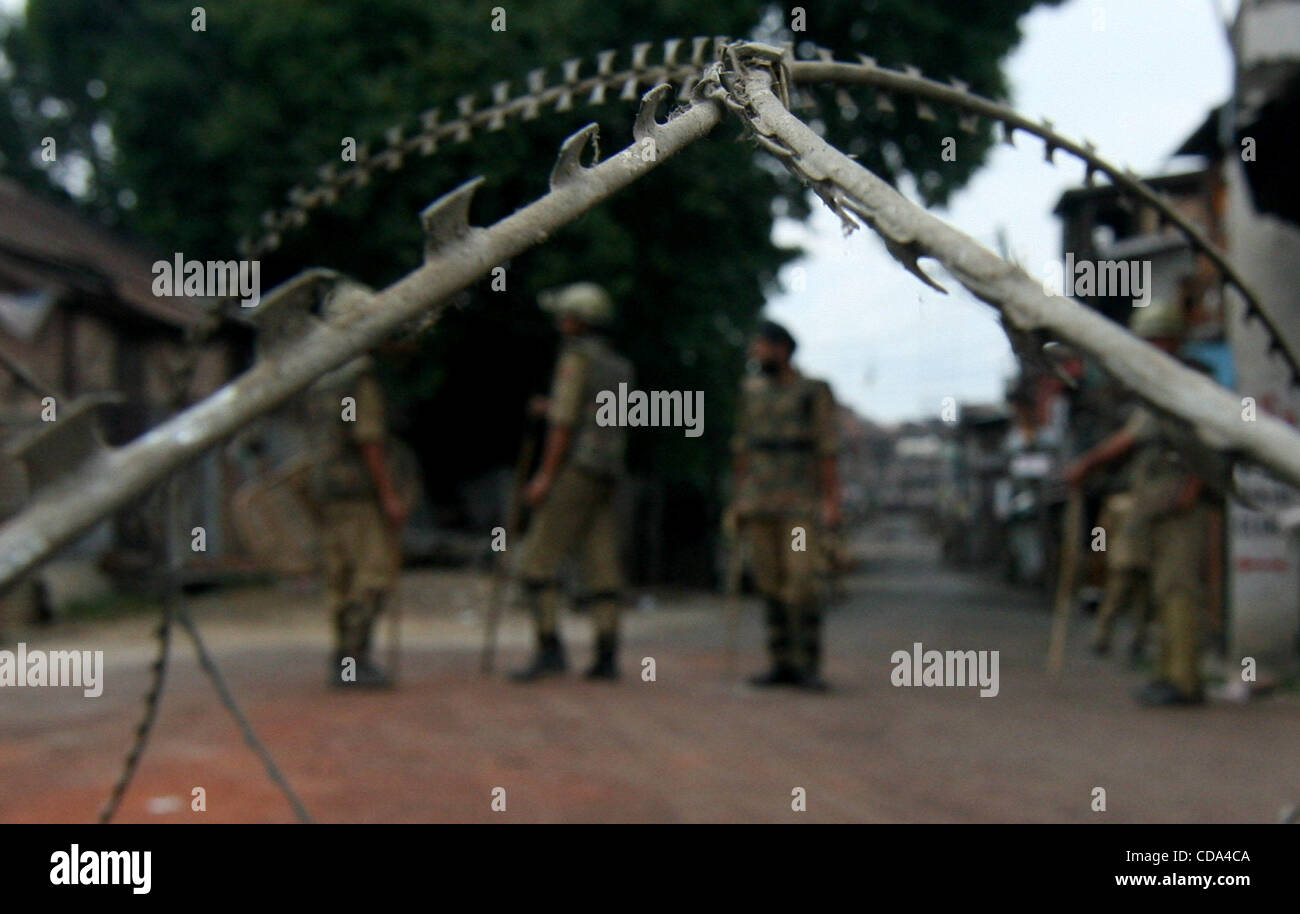 Razor Police An Indian police stands guard near razore wire during continued curfew ...