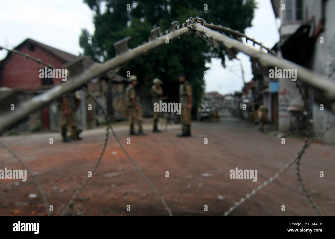 Razor Police An Indian police stands guard near razore wire during continued curfew ...