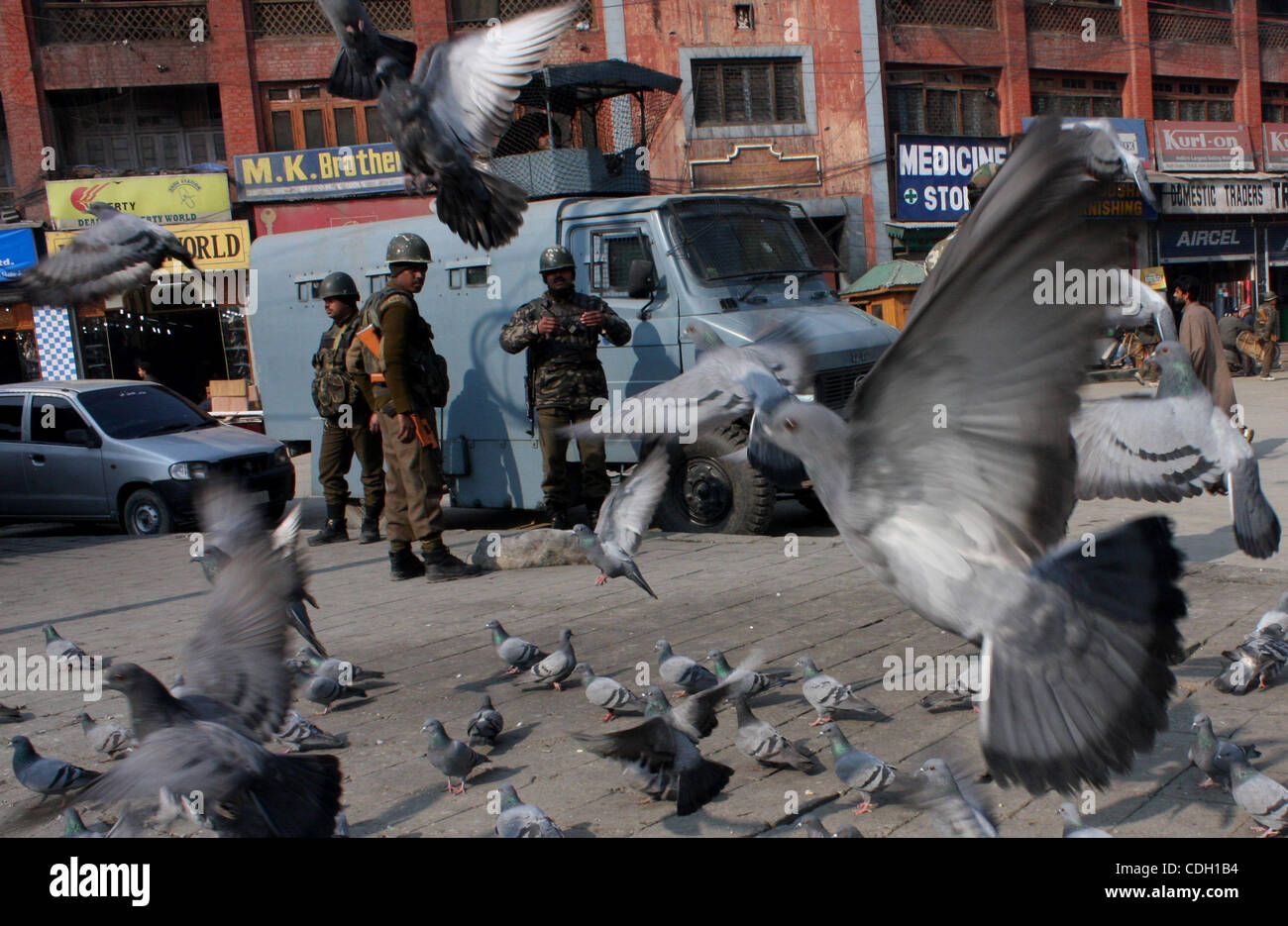 A indian  policeman stands guard in front of Kashmir's clock tower at historic Lal Chowk (Red Square) area ahead of planned national flag hoisting by India's main opposition Bharatiya Janata Party (BJP) at the tower on Republic Day, in Srinagar,the summer capital of indian kashmir  January 25, 2011. Stock Photo