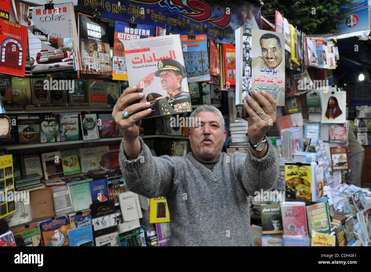 Egyptian man holds books for former Egyptian presidents Jamal Abed Al-Nasser and Anwar Al-Saddat at his bookshop in Alexandria, Egypt, 06 February 2011. Anti-government protests entered its 13th straight day in Egypt, as solutions were being mulled to bring about a power shift to end the country's p Stock Photo
