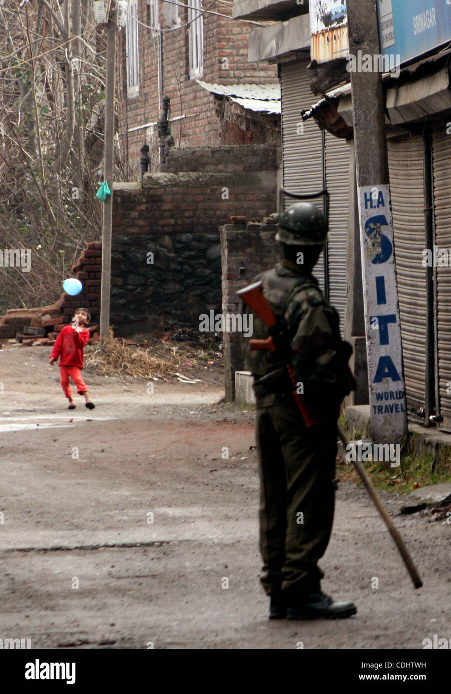 Feb 11, 2011 - Srinagar, Kashmir, India - A Kashmiri boy playing as an Indian Central Reserve Police Force (CRPF) soldiers stand guard during a one day strike to mark the 27th death anniversary of Jammu and Kashmir Libration Front (JKLF) founder Maqbool Bhat in Srinagar the summer capital of Indian  Stock Photo