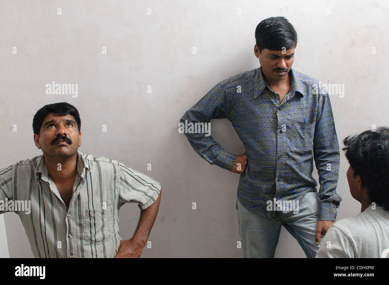 Workers wait in between takes at a music video set in Mumbai, Inida. Stock Photo