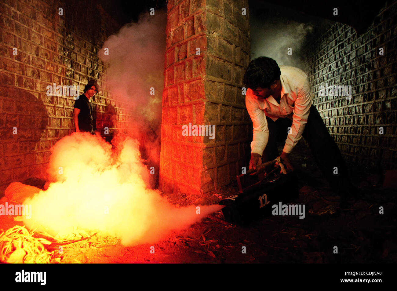 A worker uses a smoke machine on set at Film City, Mumbai Stock Photo ...