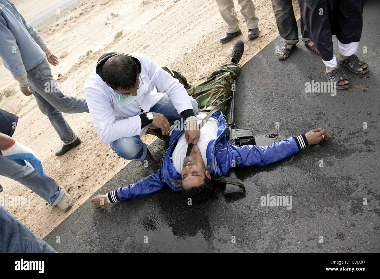 Mar 4, 2011 - Ras Lanuf, Ras Lanuf, Libyan Arab Jamahiriya - Rebel fighters take cover from shelling by soldiers loyal to Libyan leader Muammar Gaddafi during a battle near Ras Lanuf. Heavily armed rebels clashed with forces loyal to Gaddafi on Friday on the outskirts of the key oil terminal of Ras  Stock Photo