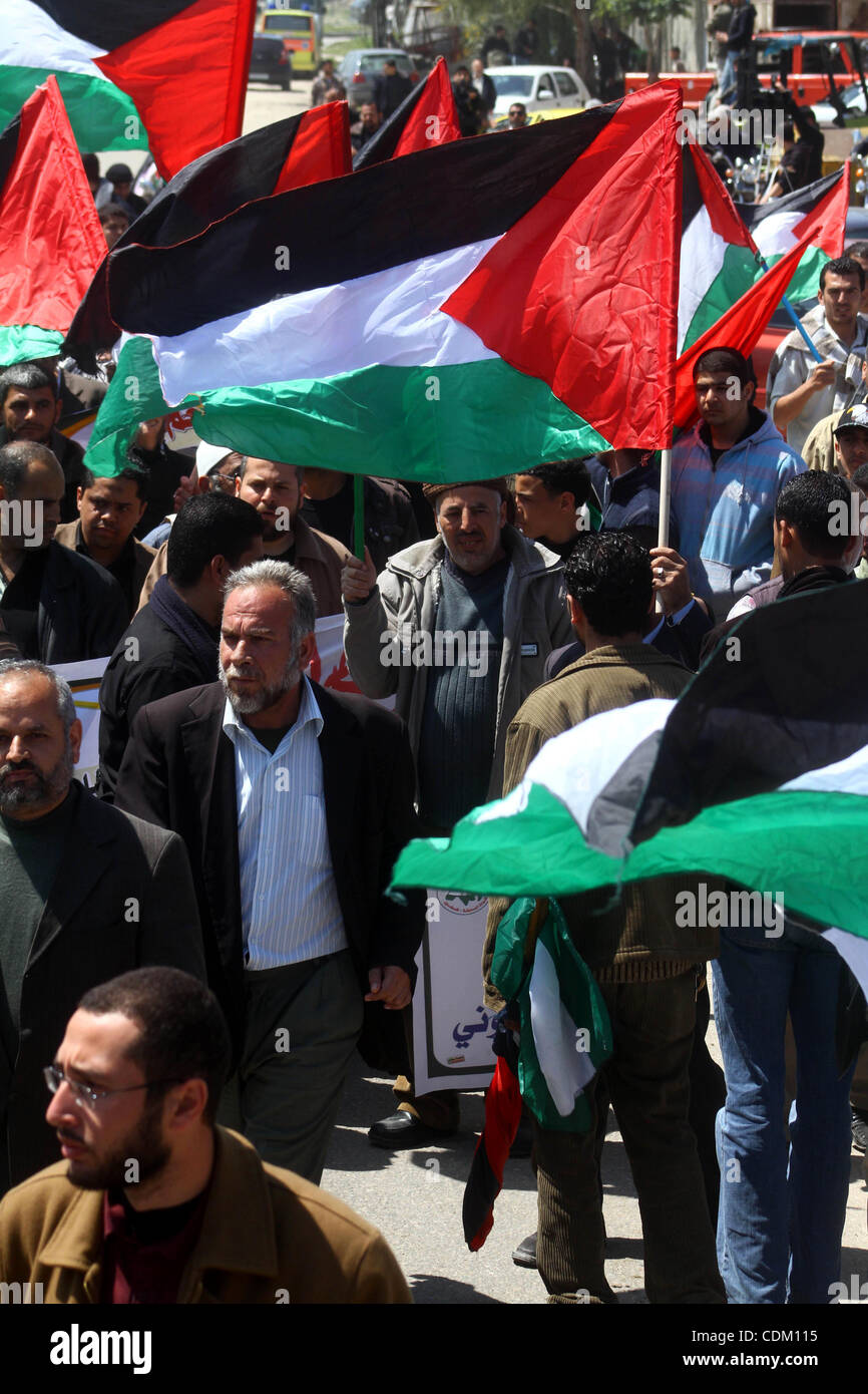 Palestinians wave their national flag and hold pictures of Palestinian prisoners jailed in Israel during a sit-in in Beit Hanun, northern Gaza Strip, on March 30, 2011 as hundreds of people across Israel and Palestinian territories were holding a series of rallies marking 'Land Day,' recalling an in Stock Photo