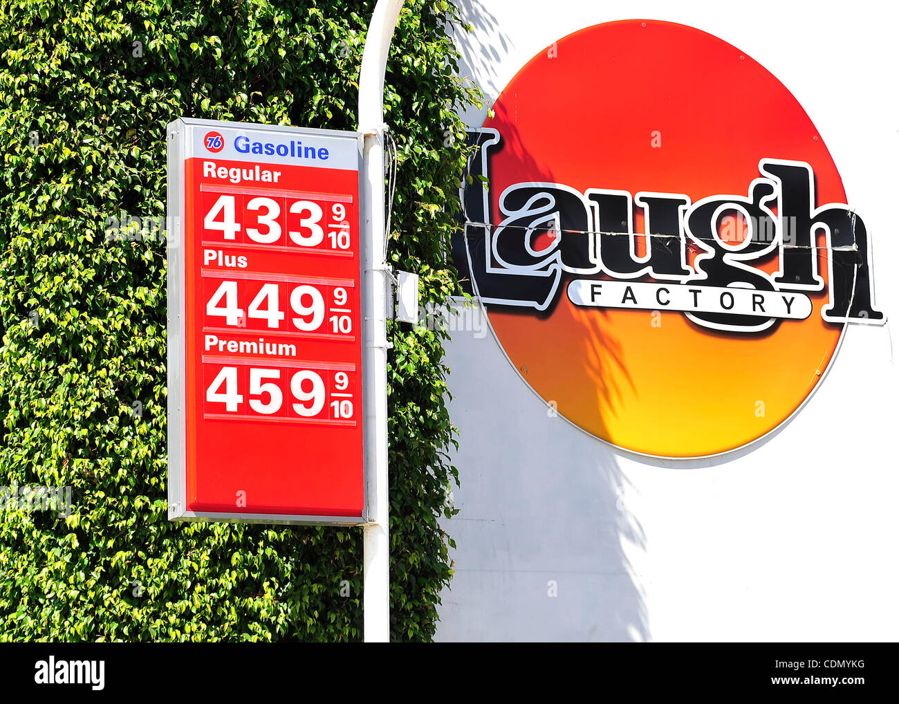 A comedy club sign is seen near gas prices posted in the $4.00 range at a 76 station in Hollywood, California on April 16, 2011.  With the price of gas above $3.50 a gallon in all but one state, there are signs that Americans are cutting back on driving, reversing a steady increase in demand for fue Stock Photo