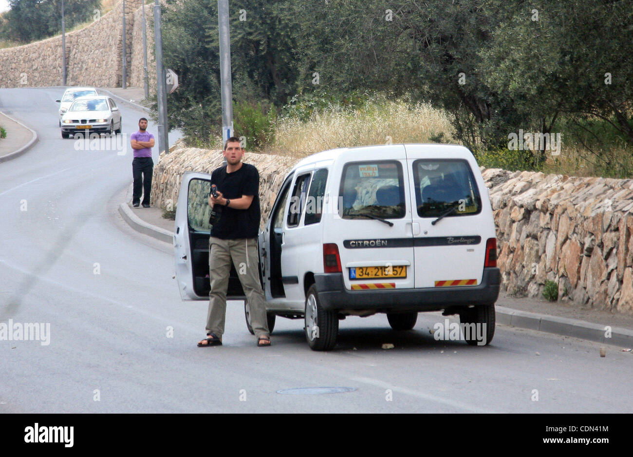 A Jewish settler gets out of his car with an assault rifle, which he fired in the air to disperse stone-throwing Palestinians who attacked him as he drove through the flashpoint east Jerusalem neighbourhood of Silwan on April 29, 2010.. Photo by Sliman Khader Stock Photo