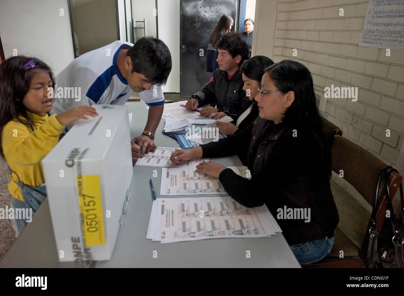 June 5, 2011 - Lima, Lima, Peru - A young girl stuffs her father's ballot in the box as he finalizes the process with his signature and a finger print. Peruvians must choose between Ollanta Humala or Keiko Fujimori for the presidency. (Credit Image: © Ric Francis/ZUMAPRESS.com) Stock Photo