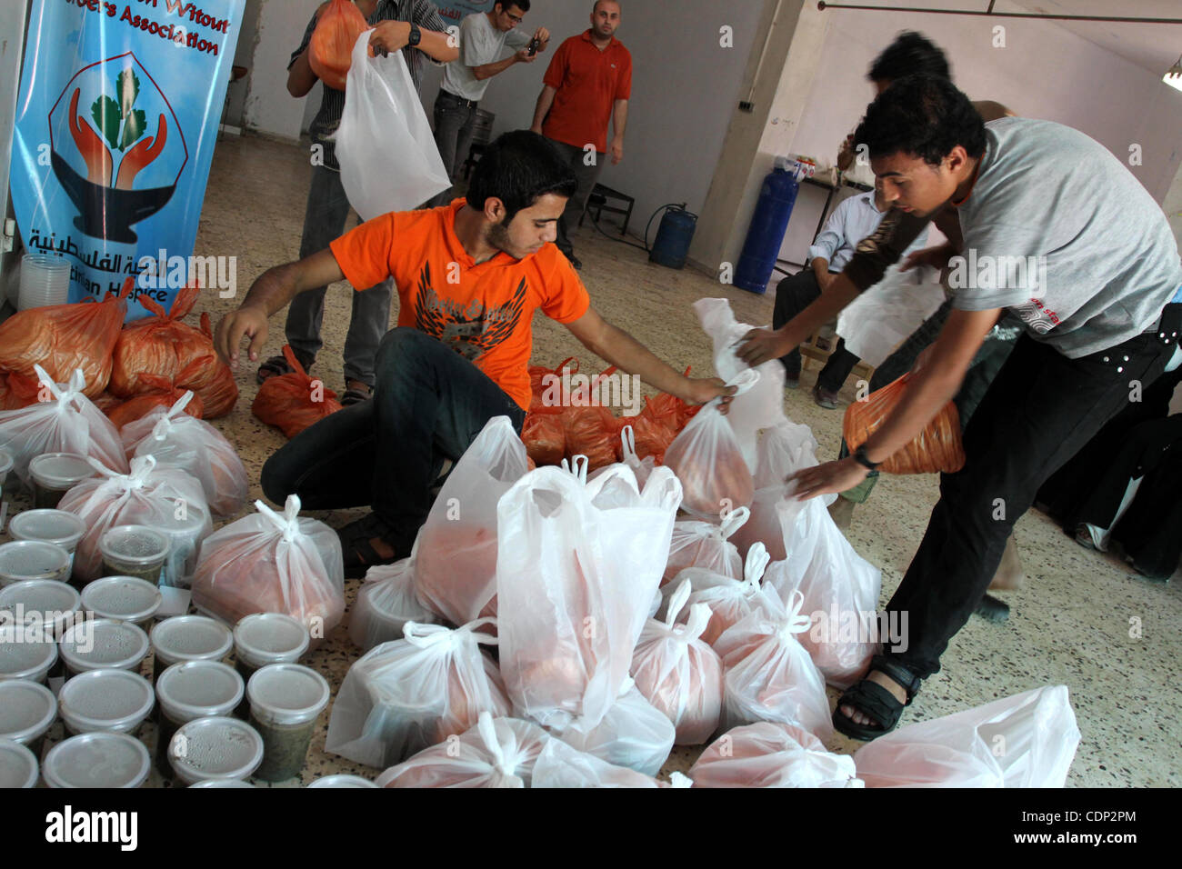 Palestinians receive donated food from an Islamic charity at a