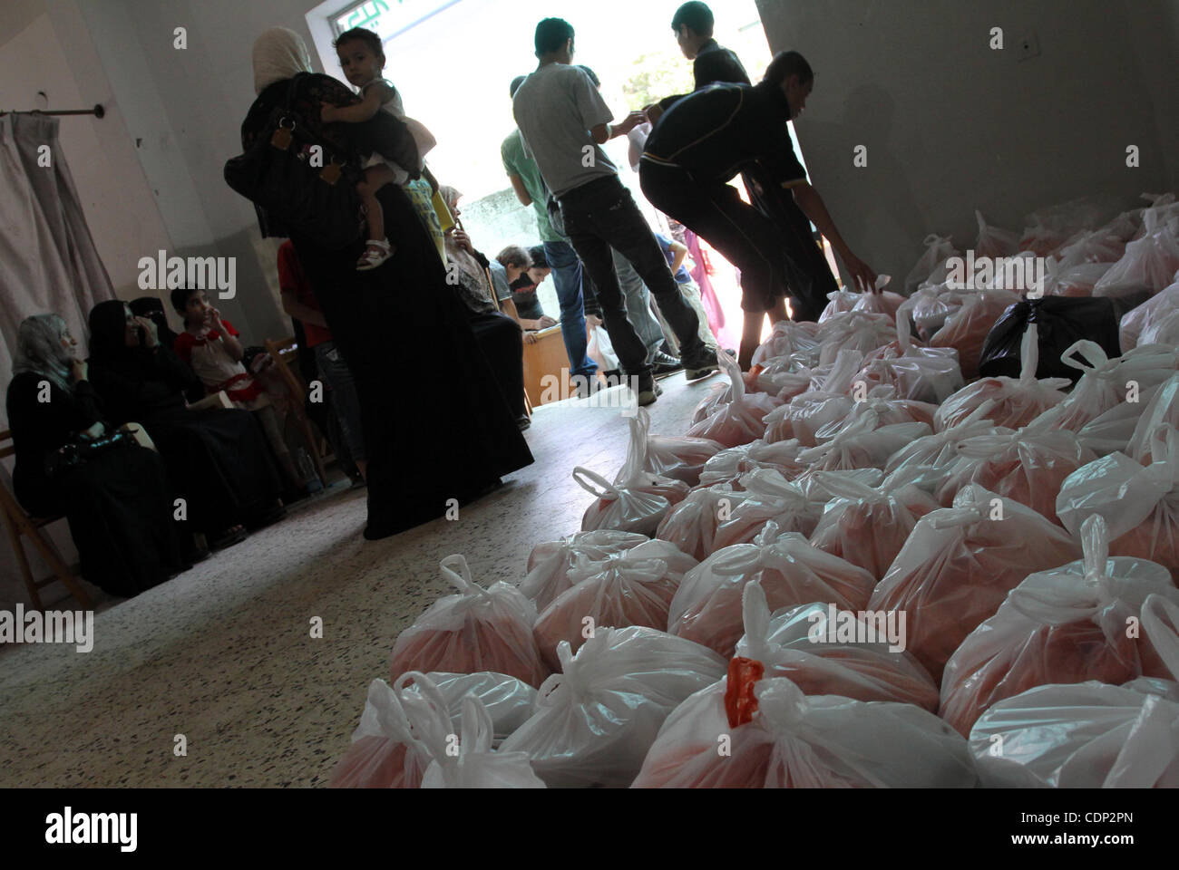 Palestinians receive donated food from an Islamic charity at a