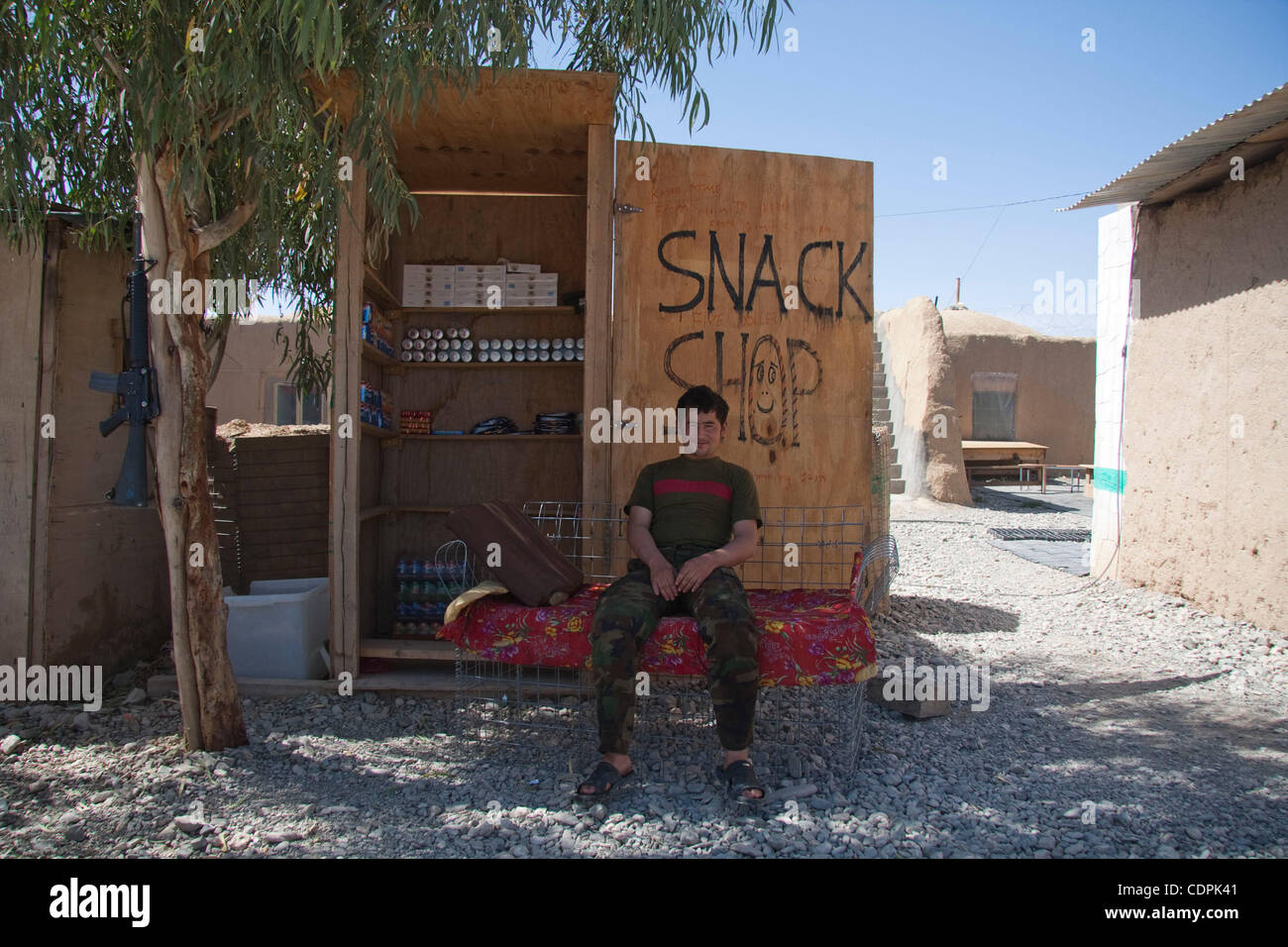 Apr 25, 2011 - Naw Zad, Helmand, Afghanistan - A soldier of 4th Company, 3rd Kandak, 2nd Regiment of 215th Afghan National Army Corps sits in front of his small store at Forward Operating Base Cafferata near the town of Naw Zad in Naw Zad district in Helmand province, Afghanistan. This Afghan Nation Stock Photo