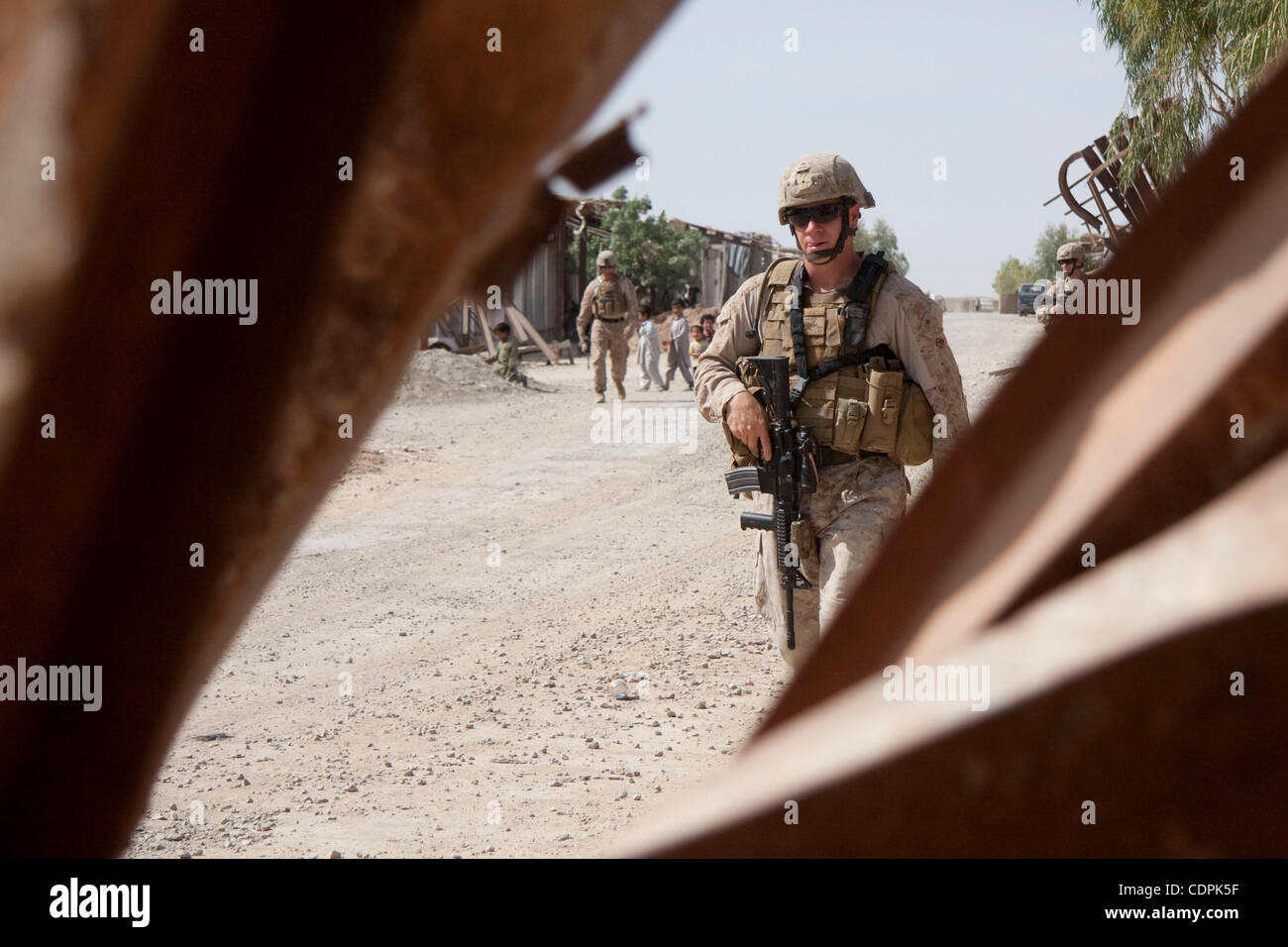 Apr 27, 2011 - Town of Naw Zad, Naw Zad district, Helmand, Afghanistan - A Marine of Lima Company, 3rd Battalion of 2nd Marine Regiment passes bent steel girders during a joint patrol with ANA soldiers from 4th Company, 3rd Kandak, 2nd Brigade of 215th Afghan National Army Corps in the Bazar of Naw  Stock Photo