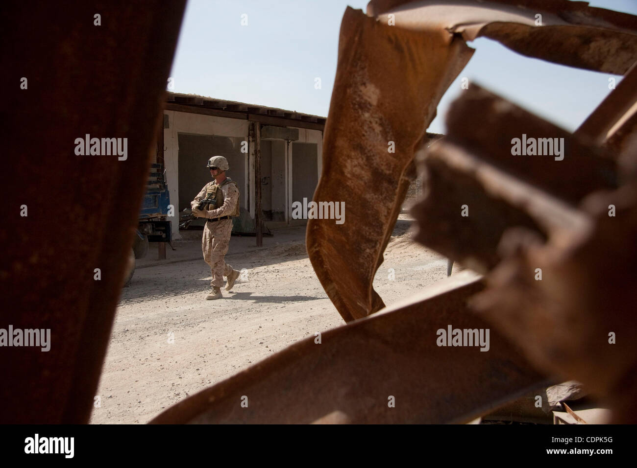 Apr 27, 2011 - Town of Naw Zad, Naw Zad district, Helmand, Afghanistan - A Marine of Lima Company, 3rd Battalion of 2nd Marine Regiment passes bent steel girders during a joint patrol with ANA soldiers from 4th Company, 3rd Kandak, 2nd Brigade of 215th Afghan National Army Corps in the Bazar of Naw  Stock Photo